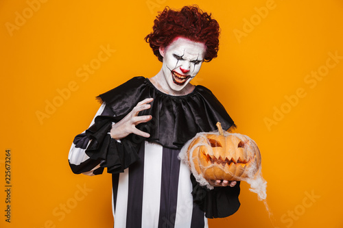 Angry man dressed in scary clown Halloween costume