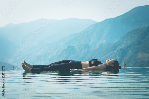 Beautiful Attractive Asian woman practice yoga Dead Body or Savasana on the pool above the Mountain peak in the morning in front of beautiful nature views in SAPA vietnam,Feel so comfortable