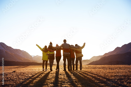 Group of friends against sunset mountains