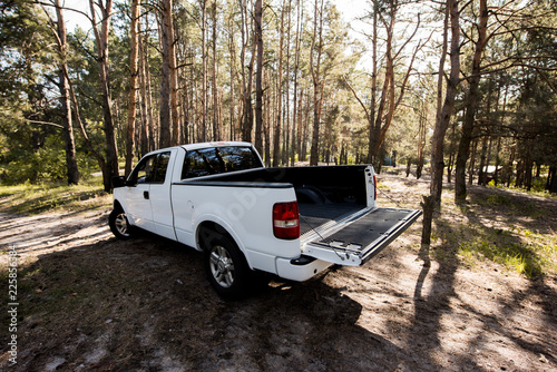 white pickup car with opened truck in forest