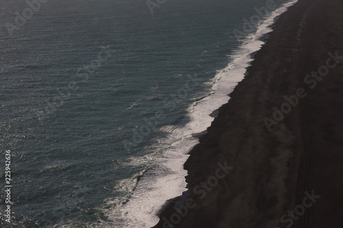 Aerial view of a black sand beach and ocean in Iceland