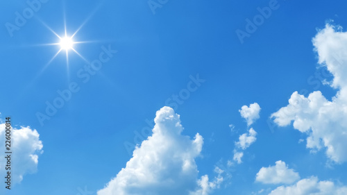 blue sky with bright sun and white clouds