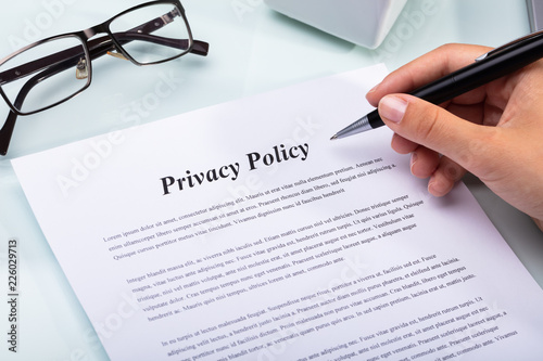 Woman Holding Pen Over Privacy Policy Form