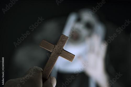 frightening evil nun screaming in front of a cross