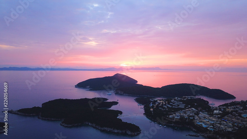 Aerial drone bird's eye view photo of iconic turquoise bay of Sivota forming a blue lagoon with beautiful colours and clouds at sunset, Ionian sea, Epirus, Greece