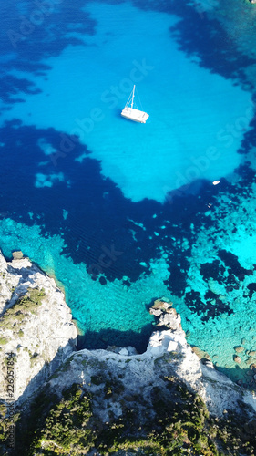 Aerial drone bird's eye view photo of tropical white rocky bay of Erimitis with turquoise clear waters and sail boats docked, island of Paxos, Ionian, Greece