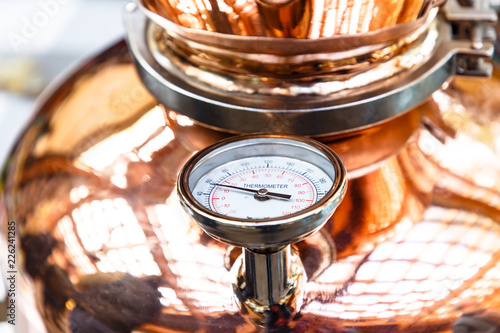 The thermometer on a copper pot for distillation of alcohol