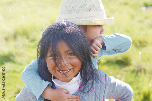 Native american girl holding her little sister in the countryside.