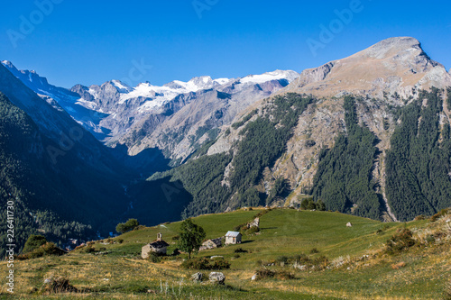 Mountain village rural houses with green fields and the Grand Paradise glacier at background. - Gimillian, Cogne, Aosta Valley, Italian Alps