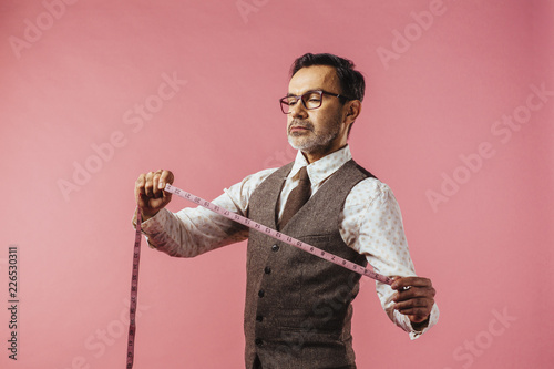 Portrait of tailor holding tape measure