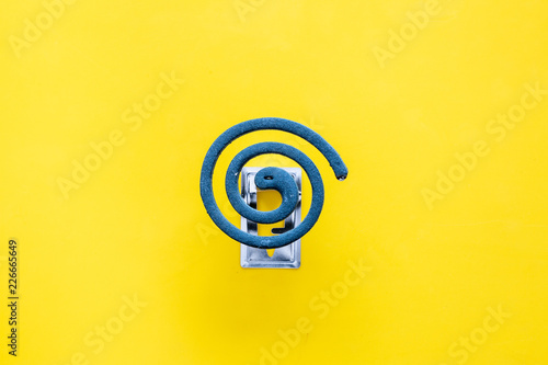 Mosquito repellent for outdoor: garden, summer house, picnic. Green spiral on yellow background top view copy space