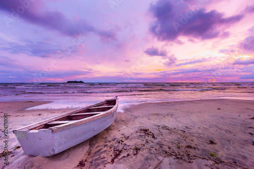 Lake Malawi sunset in Kande beach Africa, canoe boat on beach peaceful beach holiday beautiful sunset colors blue purple orange yellow in sky and clouds