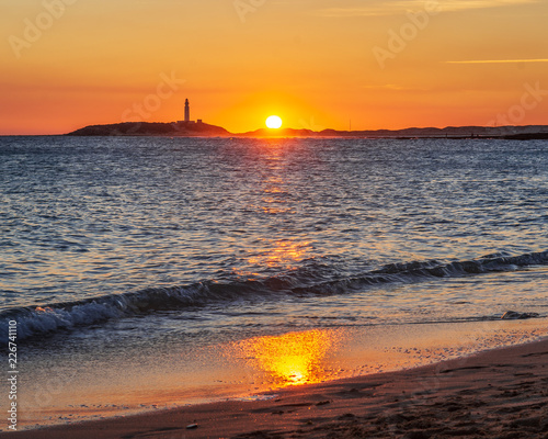 Sunset on cadiz beach with the trafalgar cape in the background