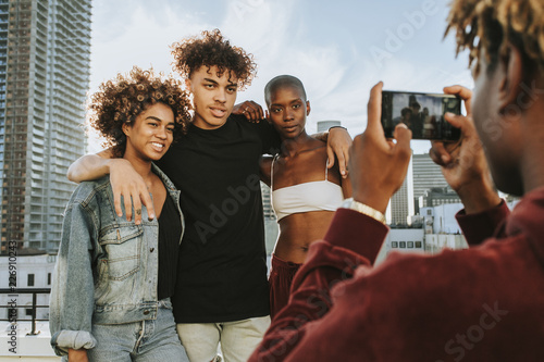 Guy taking a photo of his friends at a rooftop