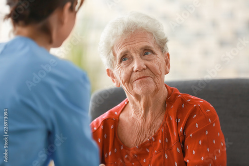 Young nurse visiting elderly woman at home