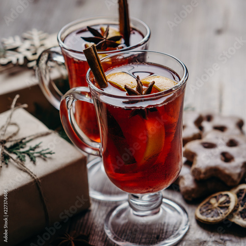 Christmas and New Year cozy holiday composition with hot mulled wine, gingerbread cookies and gift boxes. Winter holidays celebration concept