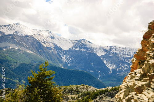 Alpine landscape in Provence-Alpes-Cote d'Azur region of France in spring. View of snow covered mountain peaks at background.