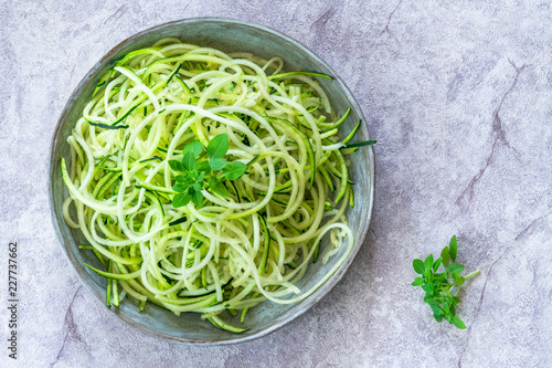 Courgette spaghetti - shredded zucchini on a plate - top view