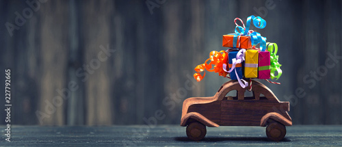 Holzauto mit bunten Geschenken