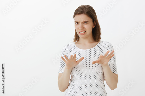 No, take it away from me. Disgusted intense and displeased woman in t-shirt, shaking palms in stop or rejection gesture, frowning and clenching teeth, being unsatisfied, expressing antipathy