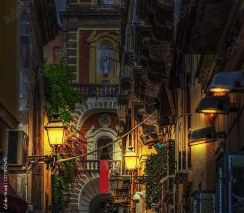 Narrow alley with Duomo steeple on the background in world famous Sorrento at night