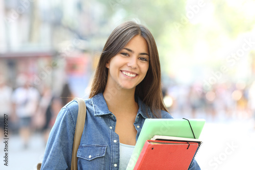 Happy student poses looking at camera in the street