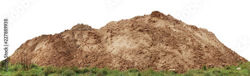 A large pile of construction sand on forest grassy site.