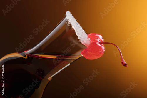 Sweet cherry on glass of liquor .