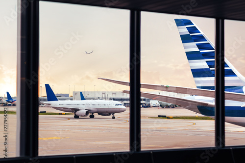 View of airplane fuselage tail through window at airport