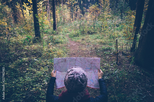 Young traveler woman with map,at autumn green forest in sunny day. Relaxing outdoor, hiking lifestyle