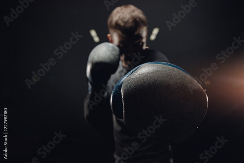 Portrait muay thai silhouette boxer man in gloves against dark background. Concept training boxing.