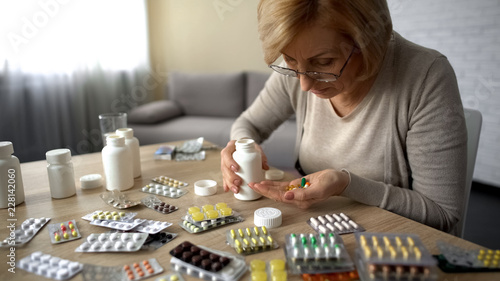 Senior lady taking too much pills, feeling unwell, heart problem self-medication