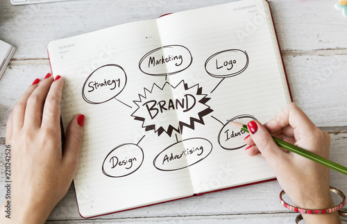 Young woman drawing brand in a notebook