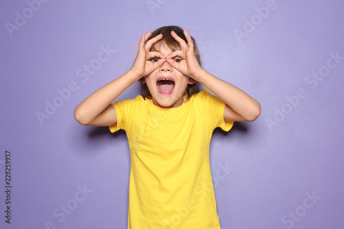 Funny little boy in t-shirt on color background