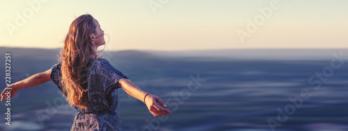 Christian worship and praise. A young woman with her hands raised in worship and praise to god.