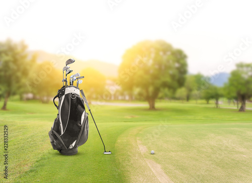 Golf equipment and golf bag , putter, ball on green and golf course as background.