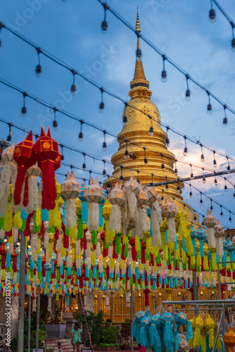 Golden pagoda at Wat Phra That Haripunchai Lamphun with Thai lanna lantern at night .