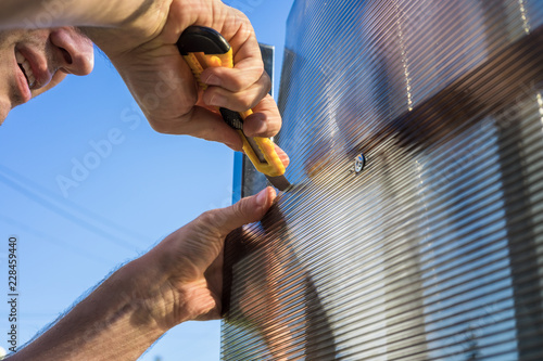 Man cutting a piece of polycarbonate