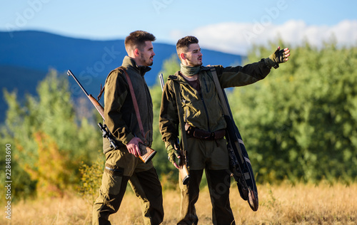 Hunting with partner provide greater safety fun and rewarding. Gamekeeper rifles nature environment. Gamekeepers walk mountains background. Gamekeeper occupation concept. Gamekeepers sunny fall day