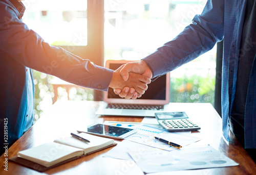 Successful of businessmen shaking hands after discussing good deal of trading contract in the office, Business partnership meeting and greeting concept, success, dealing, greeting and partner concept.