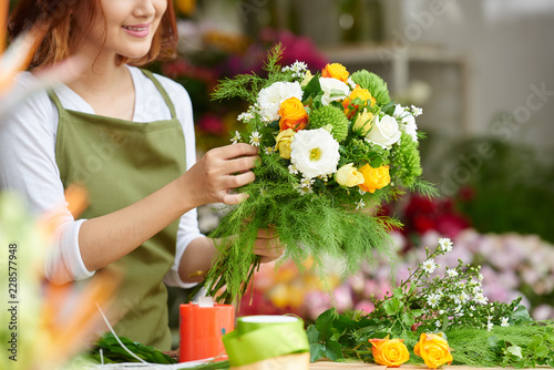 Close-up image of female florist making beautiful bouquet of fresh flowers