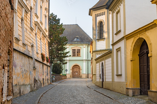 Cobblestone street cityscape with baroque and dilapidated buildings in the old town of Olomouc, Czech Republic. 