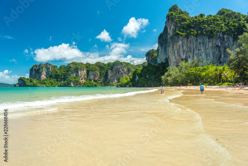 Railay Beach West. Cliffs covered with jungles and clear water during a beautiful sunny day in July (low season). Krabi, Thailand