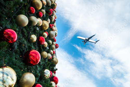 Decorated Christmas tree and airplane in blue sky