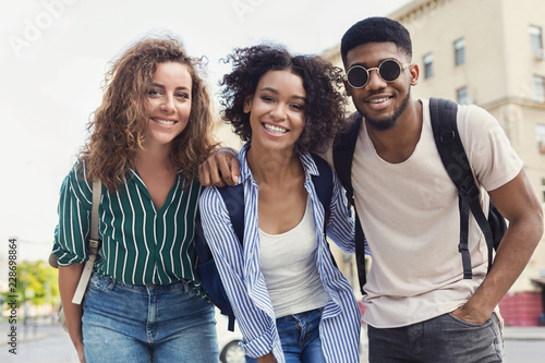 Happy hipster friends hangout on city street