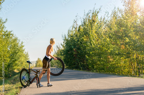 Sexy girl with a road bike and a flat tire looking for help