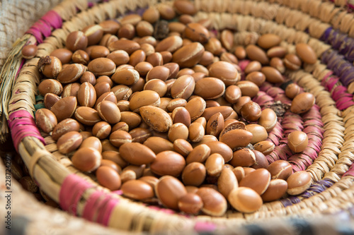 Close up of Argan nuts (Argania spinosa) in a cooperative straw basket in Morocco. Produced only in Morocco, this fruit is widely used in the cosmetics industry.