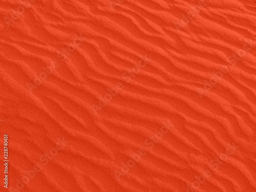 texture of red sand waves on the beach or in the desert. the ripples of the sand is diagonal.