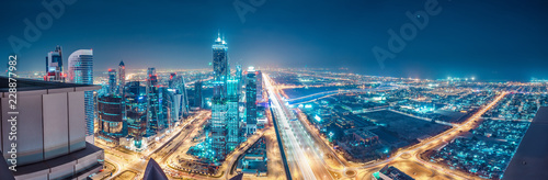 Spektakularna miejska panorama z kolorowymi iluminacjami miasta. Widok z lotu ptaka na autostradach i drapaczach chmur w Dubaju, Zjednoczone Emiraty Arabskie.