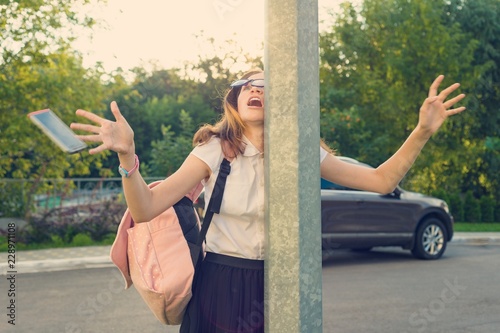 Portrait of young inattentive girl, distracted by mobile phone. Girl crashed into street post, dropped phone